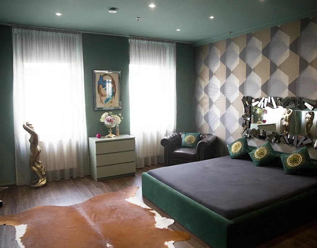 Zimmer im Studio Amore 63 mit grünem Bett, Sessel und Spiegelwand